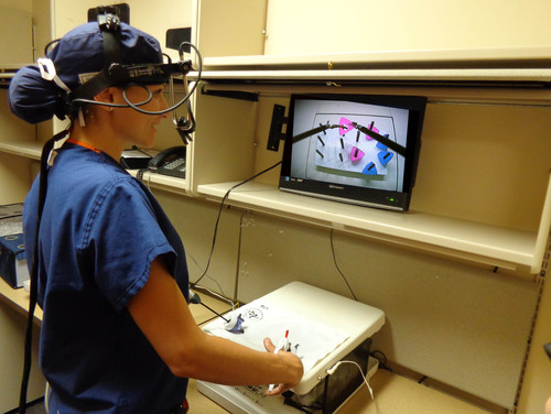 Una cirujana con el eye-tracker (aparato de registro de movimientos oculares) en momentos previos a la realización de la tarea de simulación laparoscópica. Foto: UGR.