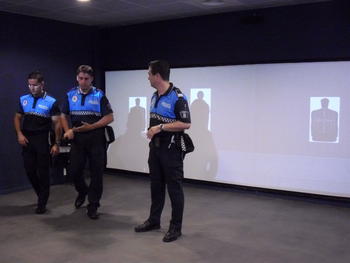 Uno de los instructores explica el entrenamiento virtual que van a realizar dos policías.
