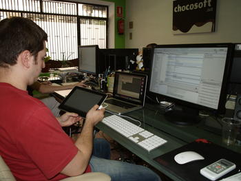 Un informático de Chocosoft, trabajando con el ordenador y la tableta digital.
