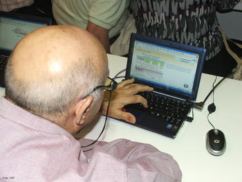 Una persona mayor utiliza un ordenador portátil.