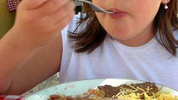 Una niña ingiere alimentos. (Fotografía: UDEA)