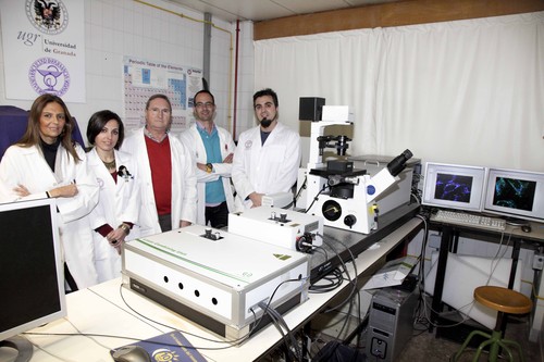Los investigadores de la UGR autores de la patente posan junto al microscopio de fluorescencia. Foto: UGR.