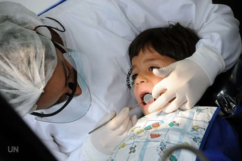 Un dentista revisa la dentadura de un niño.