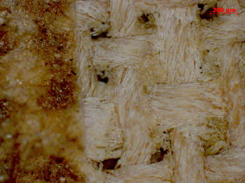 La imagen muestra un trozo de lino sucio (izquierda) y tras la aplicación del láser
