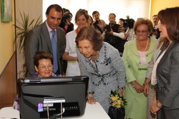 Una usuaria muestra sus trabajos a la Reina Sofía durante la inauguración del centro de atención integral para enfermos de alzhéimer de León.
