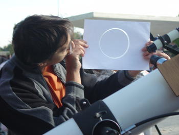 Un miembro del Grupo Universitario de Astronomía muestra el reflejo del eclipse a través de una imagen tomada por un telescopio