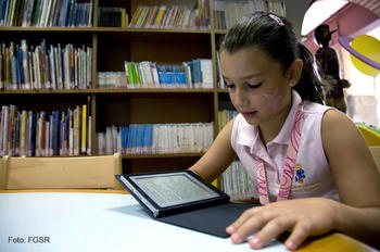 Una niña, con un libro electrónico.