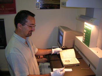 Un experto en digitalización manipula un libro antiguo de la Biblioteca Histórica de la Universidad de Salamanca.