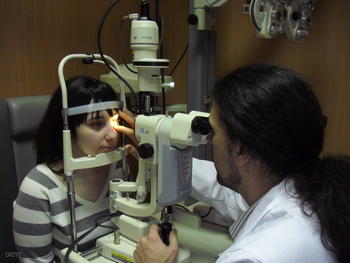 el coordinador de ópticos optometristas de Instituto de Oftalmobiología Aplicada (IOBA) de Valladolid, Raúl Martín, observa el ojo de una paciente.