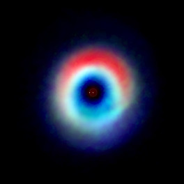 Imagen compuesta del sistema binario HD 142527 a partir de datos obtenidos por el Atacama Large Millimeter/submillimeter Array, donde se aprecia un arco de polvo (en rojo) y un anillo de monÃ³xido de carbono (azul y verde). 