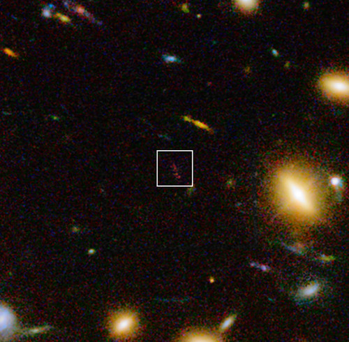 Vista infrarroja de la lejana y polvorienta galaxia A1689-zD1 detrás del cúmulo de galaxias Abell 1689. Crédito: ESO/J. Richard