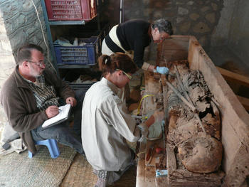 Los investigadores dirigidos por José Manuel Galán limpian una momia encontrada en la excavación.